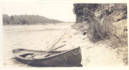 Historic photo of canoe on the lake shore.