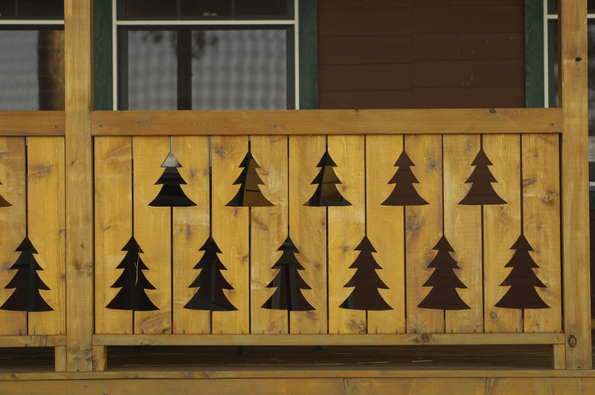 Cabin patio fence with fir tree shaped holes