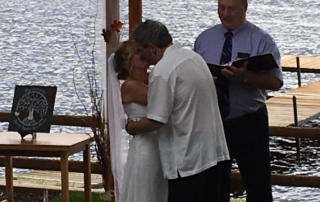 Bride and Groom kissing during lakeside wedding ceremony